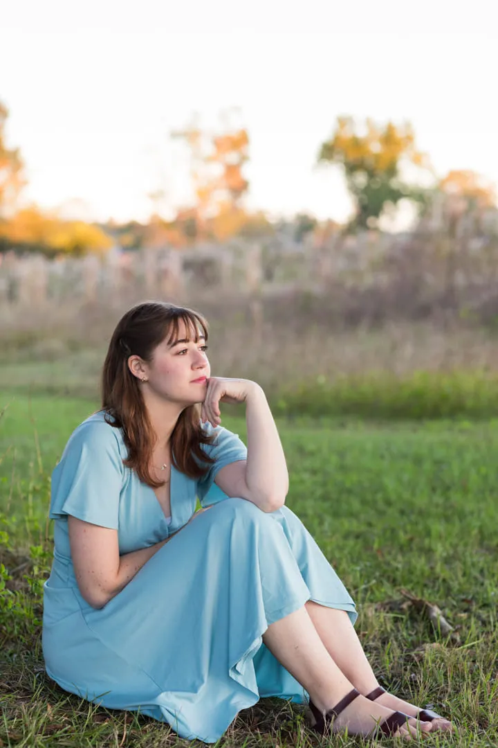 Graduation session in a grass field during a sunset